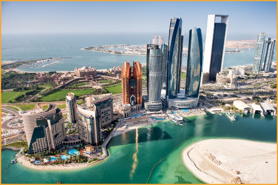 Aerial photograph of Abu Dhabi’s Corniche and turquoise shoreline, highlighting the UAE’s safe, modern infrastructure and its appeal for travellers seeking relaxed, well-maintained destinations