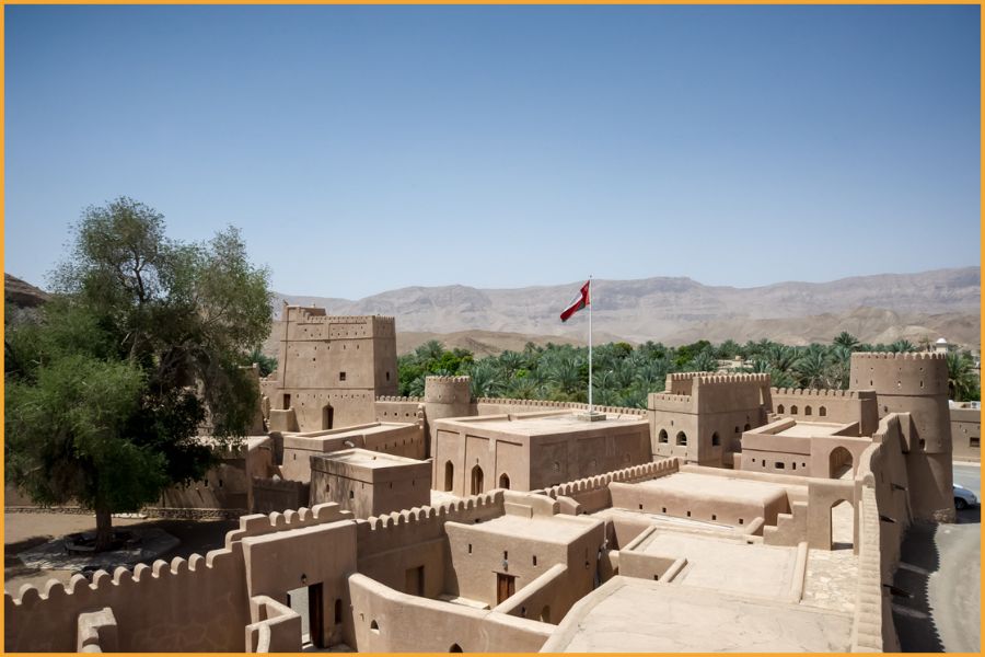 Historic fort in Oman with mountain backdrop, showcasing the country’s rich heritage and calm, welcoming environment for visitors.